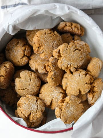 A cookie tin filled with molasses crinkle cookies.